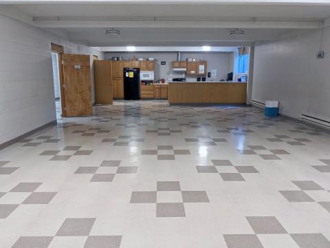 Empty Mayflower Room space with kitchen at end